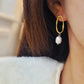 Woman wearing gold hoop earrings with freshwater baroque pearl drop for wedding.