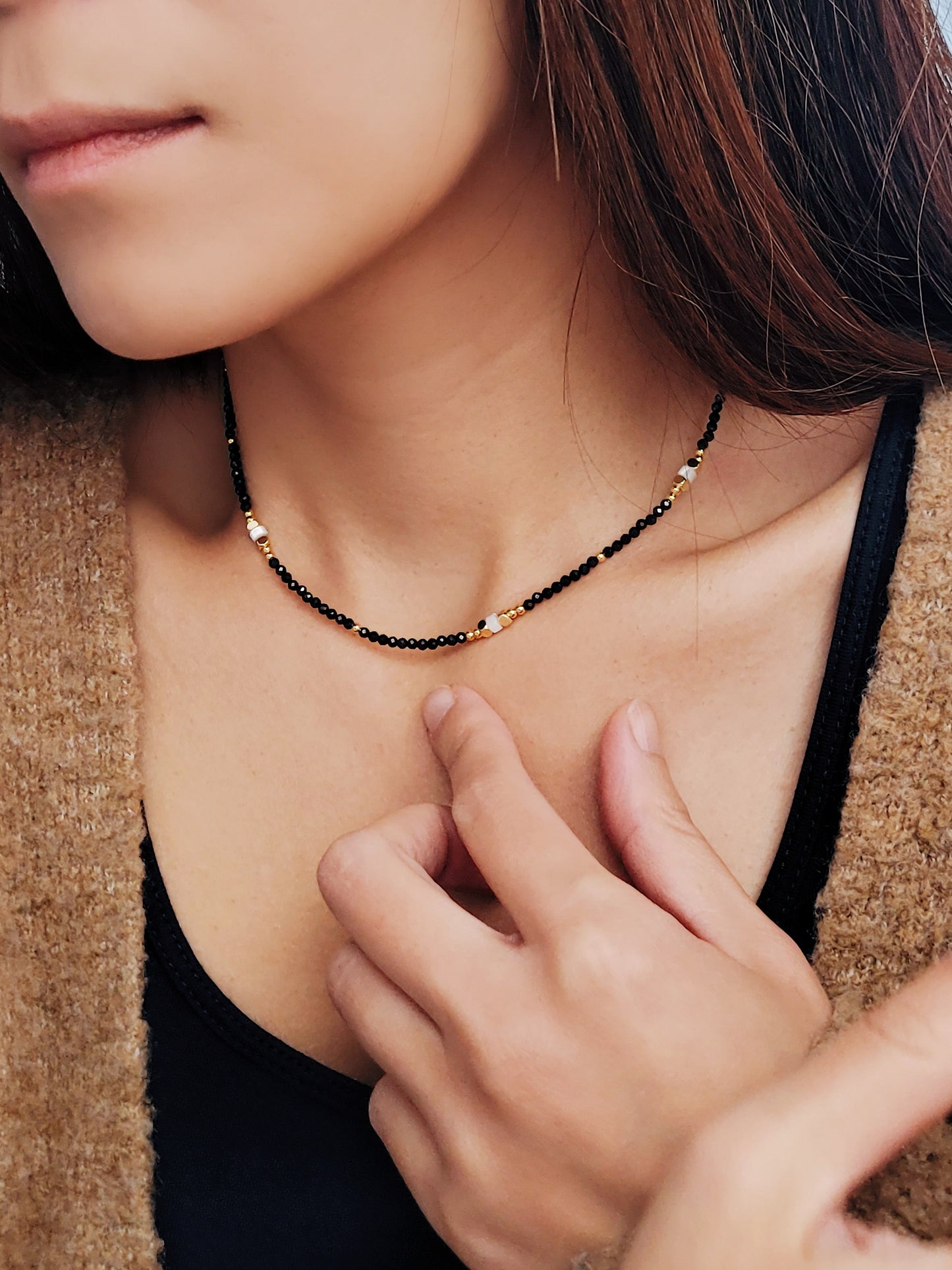 A woman gracefully wears her elegant black spinel beaded necklace, showcasing its stylish allure and sophistication.