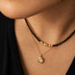 A close-up of a woman wearing a delicate 2mm black spinel beaded choker necklace featuring a center accent cluster of organic, textured 22k gold vermeil nuggets layered with a round diamond pendant necklace.