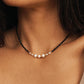 Black spinel and freshwater pearl choker necklace with 18k gold plated sterling silver accents, worn by a woman. Delicate pearl and gemstone necklace for everyday wear, layering and elegant bridal jewellery.