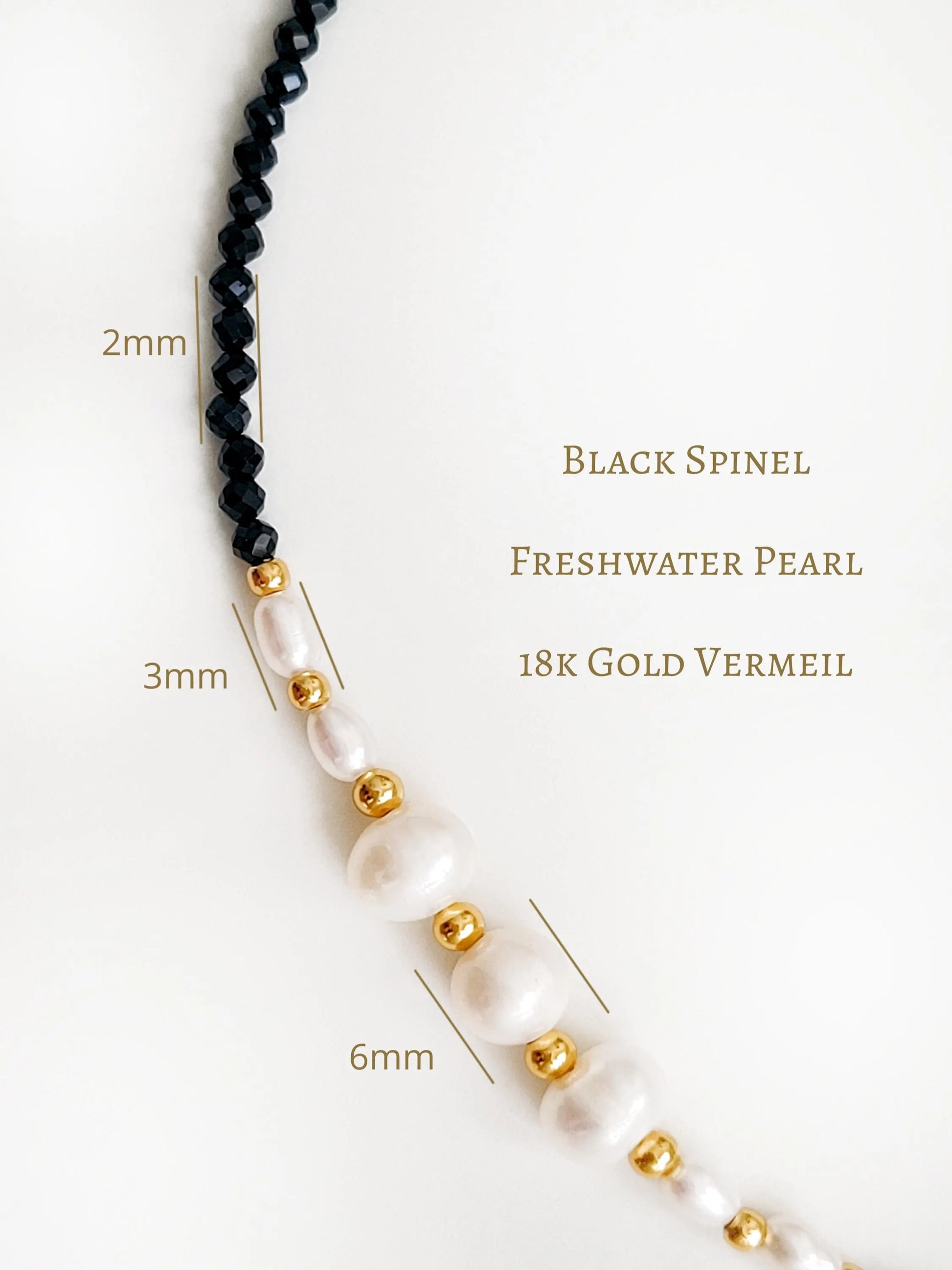 Necklace with black spinel, freshwater pearl, and 18k gold vermeil beads on a white background.