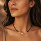 Black spinel and freshwater pearl choker necklace with 18k gold plated sterling silver accents, worn by a woman. Delicate pearl and gemstone necklace for everyday wear, layering and elegant bridal jewellery.