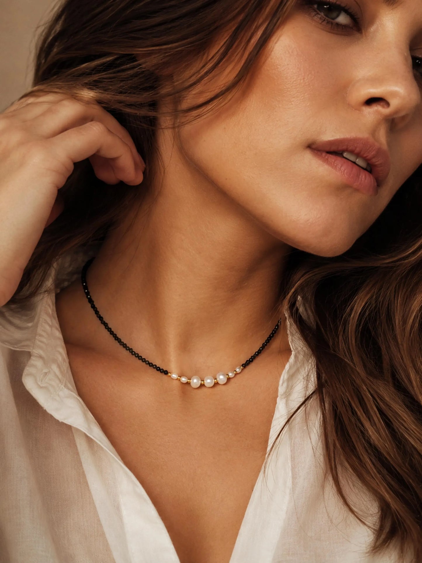 Handmade black spinel and freshwater pearl choker necklace with gold accents, worn as a minimalist bridal and everyday necklace.