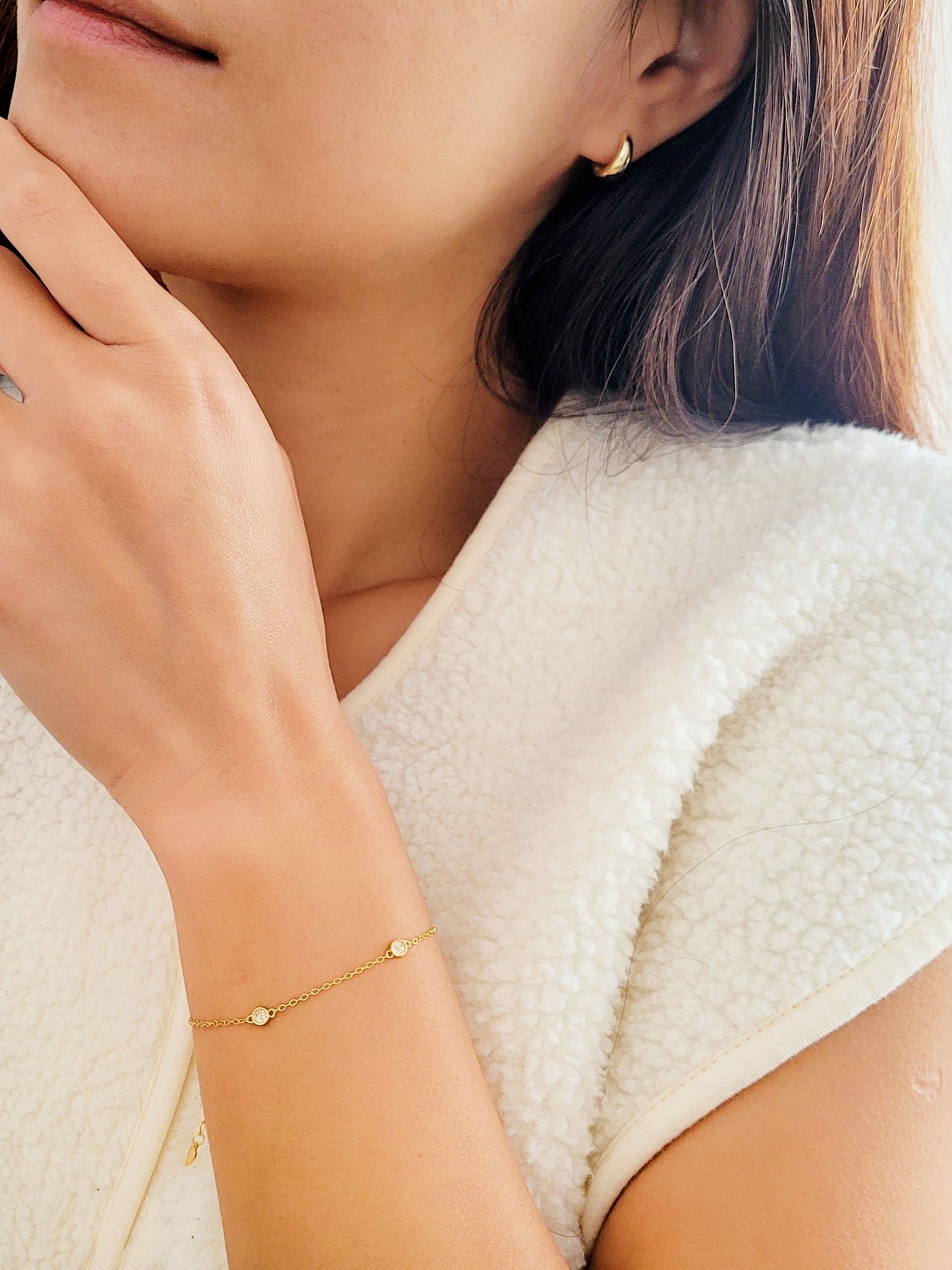 A chic gold circle bracelet rests on a wrist, embodying a minimalist style that's great for layering with other pieces. 