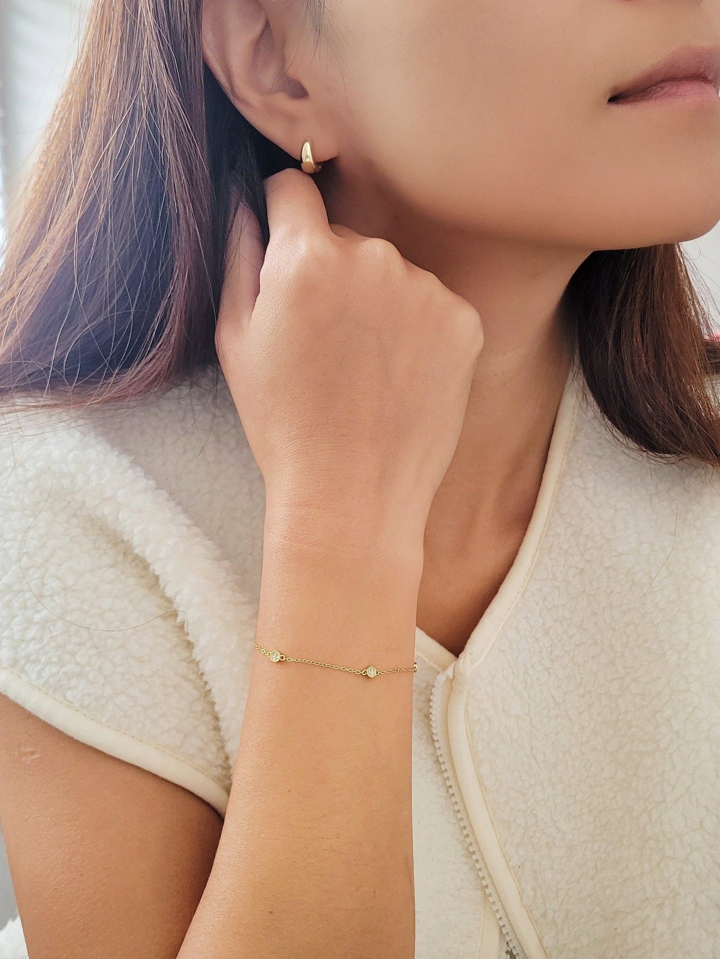 A minimalist gold circle bracelet elegantly worn on a wrist, perfect for layering with other accessories. 