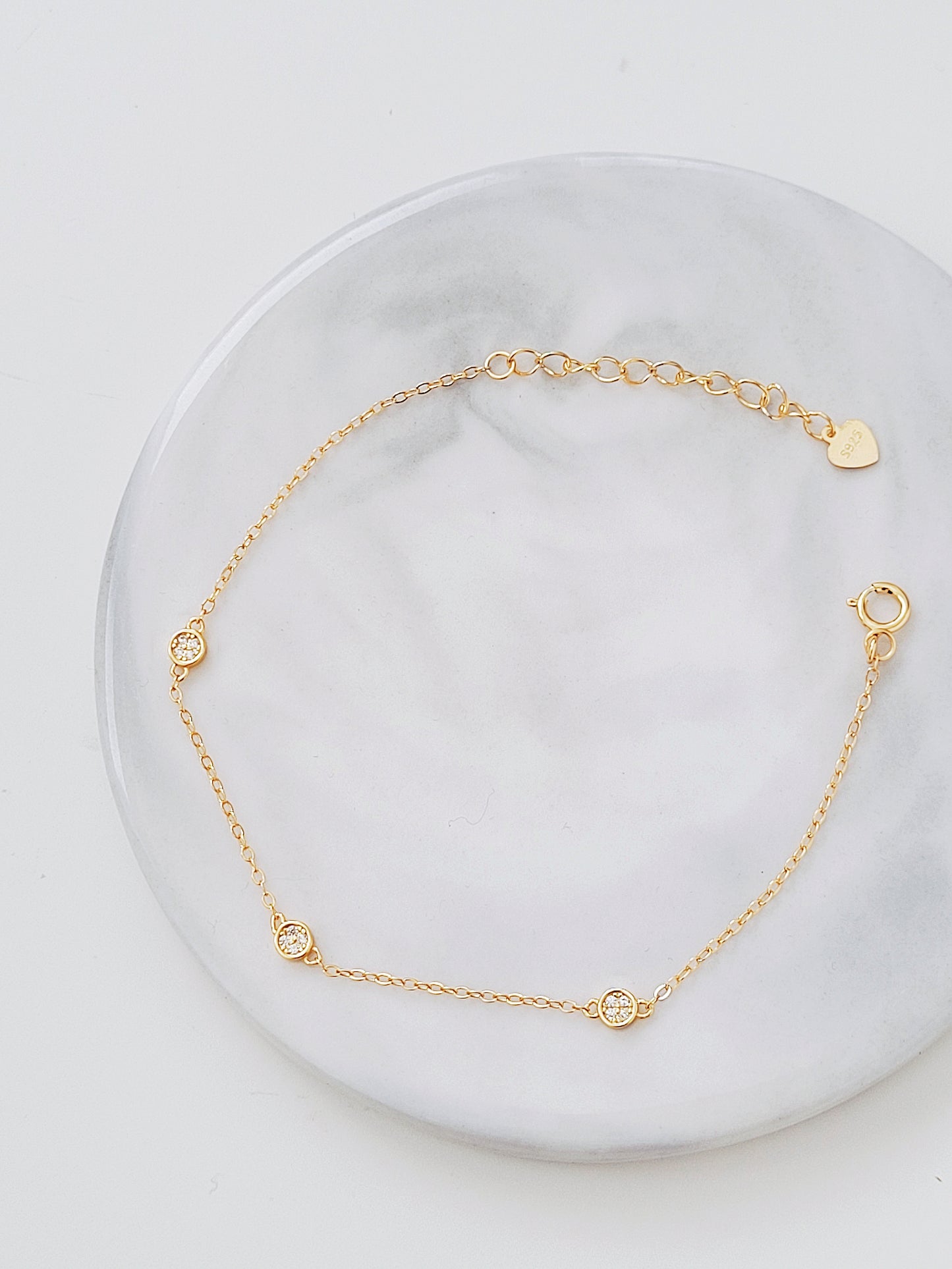 a delicate circle bracelet on a display plate