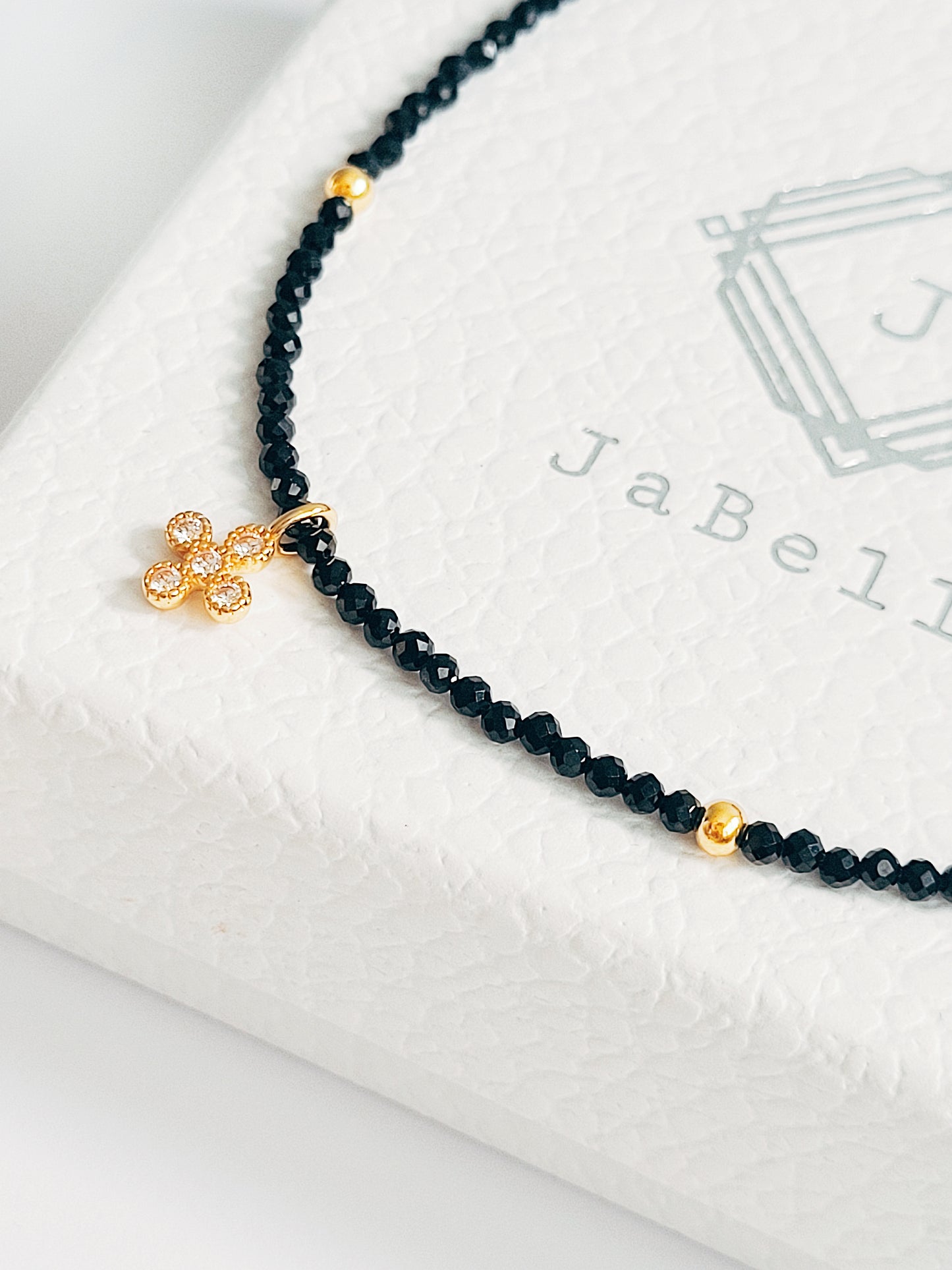 Faceted black spinel bead choker with a gold clover pendant. Ideal gift for sister, anniversaries or birthdays.