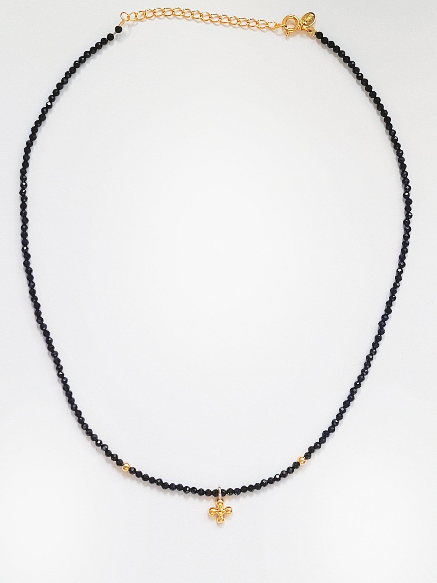 Elegant black spinel choker necklace with a versatile gold and zircon clover charm, perfect for adding sparkle and sophistication.