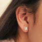 Dainty 925 sterling silver four-leaf clover stud earring worn on a model, featuring a textured finish for a minimalist everyday look.
