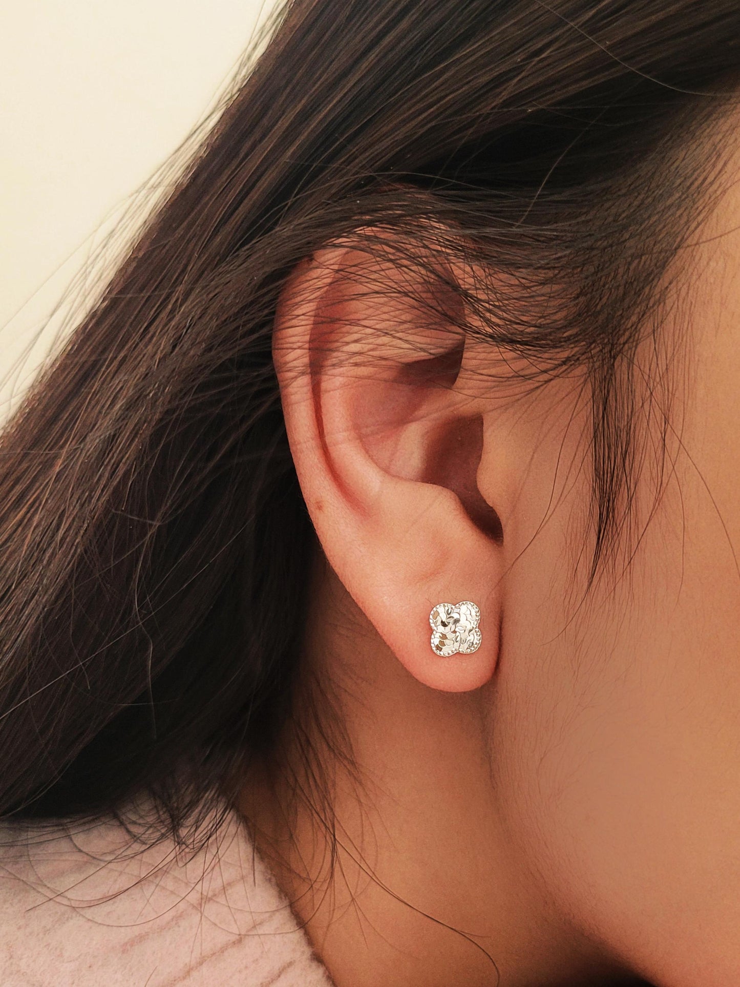 Dainty 925 sterling silver four-leaf clover stud earring worn on a model, featuring a textured finish for a minimalist everyday look.
