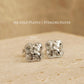 Close up of a pair of dainty clover stud earrings in 925 sterling silver, showing the intricate textured detail on an aesthetic beige stone surface, perfect gift for wife