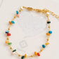 A gold beaded bracelet with multi-colored onyx gemstone displayed on a gift message card