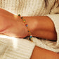 Colorful beaded bracelet on a person's wrist against a neutral background