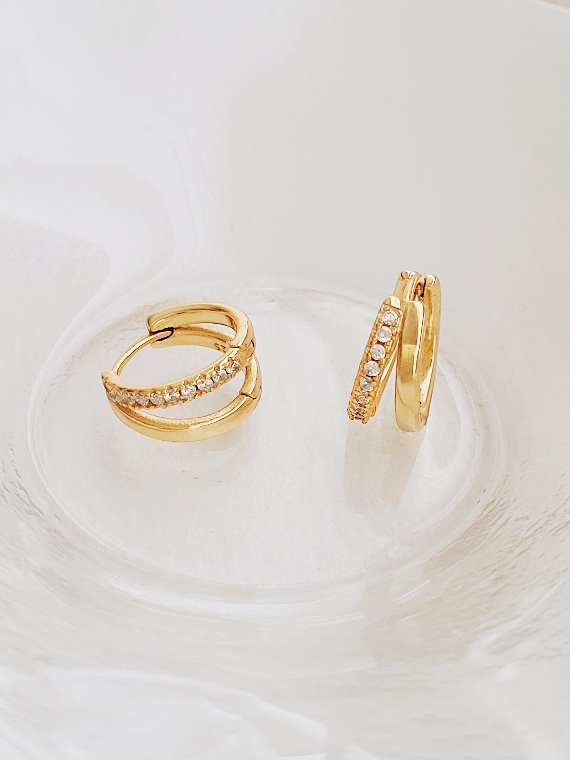 Stylish gold double hoop earrings with a sleek design, perfect for adding a touch of elegance to any outfit.