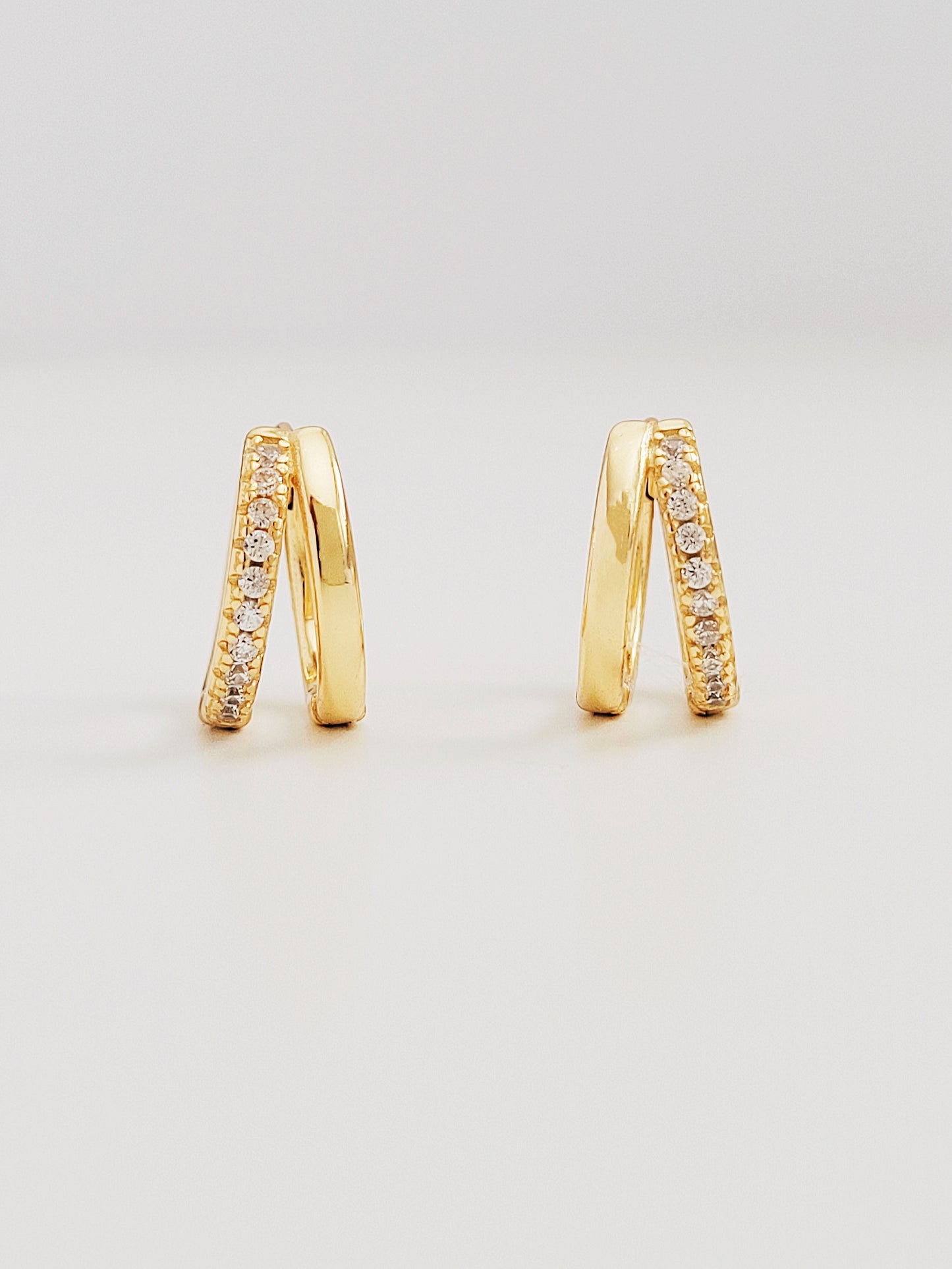 Elegant gold double huggie hoop earrings adorned with sparkling diamond-styled cubic zirconia, perfect for adding a touch of glamour.