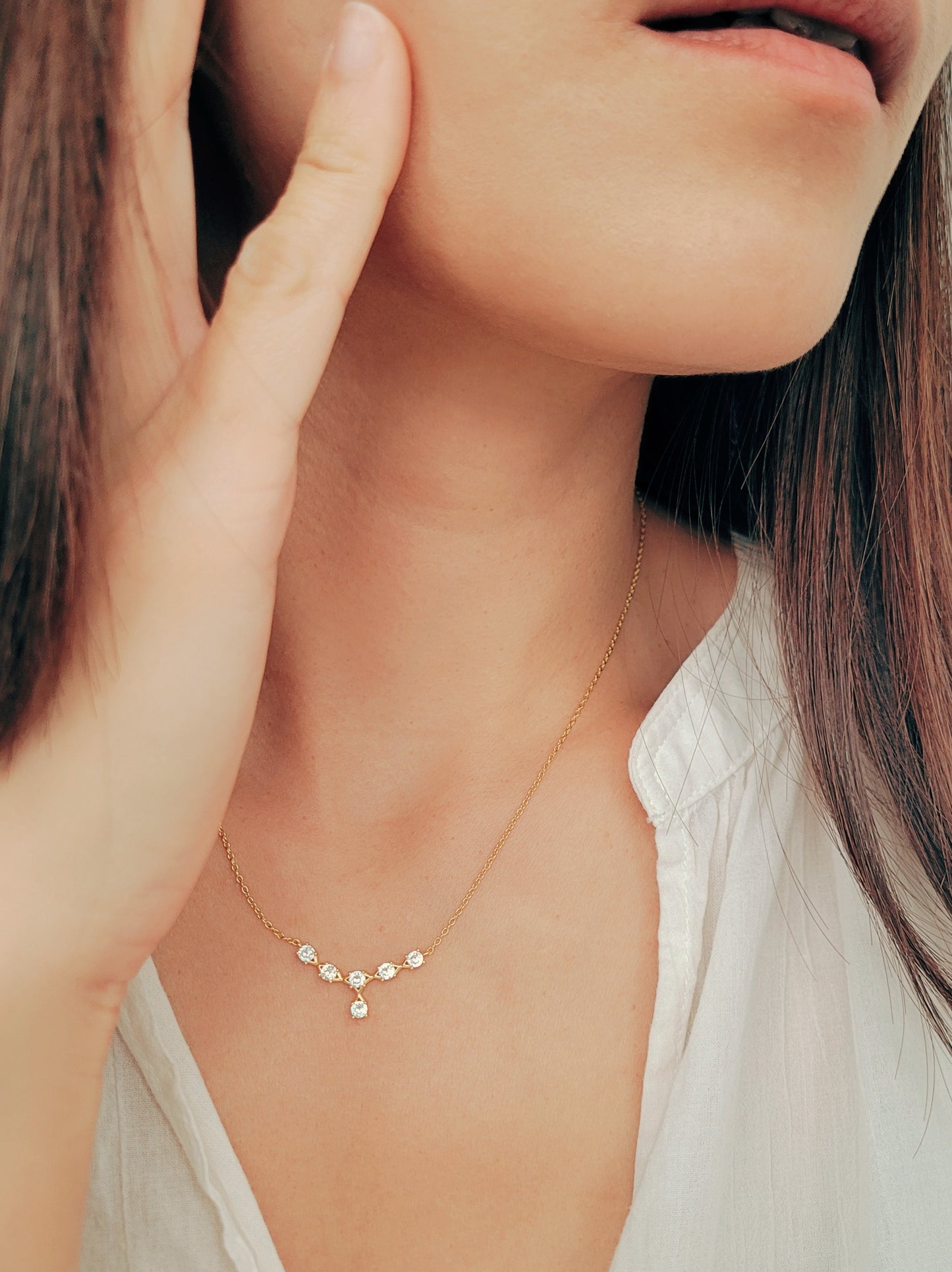 A model wearing an elegant gold plated crown necklace with delicate crystals, ideal for weddings, anniversaries, and gifting.