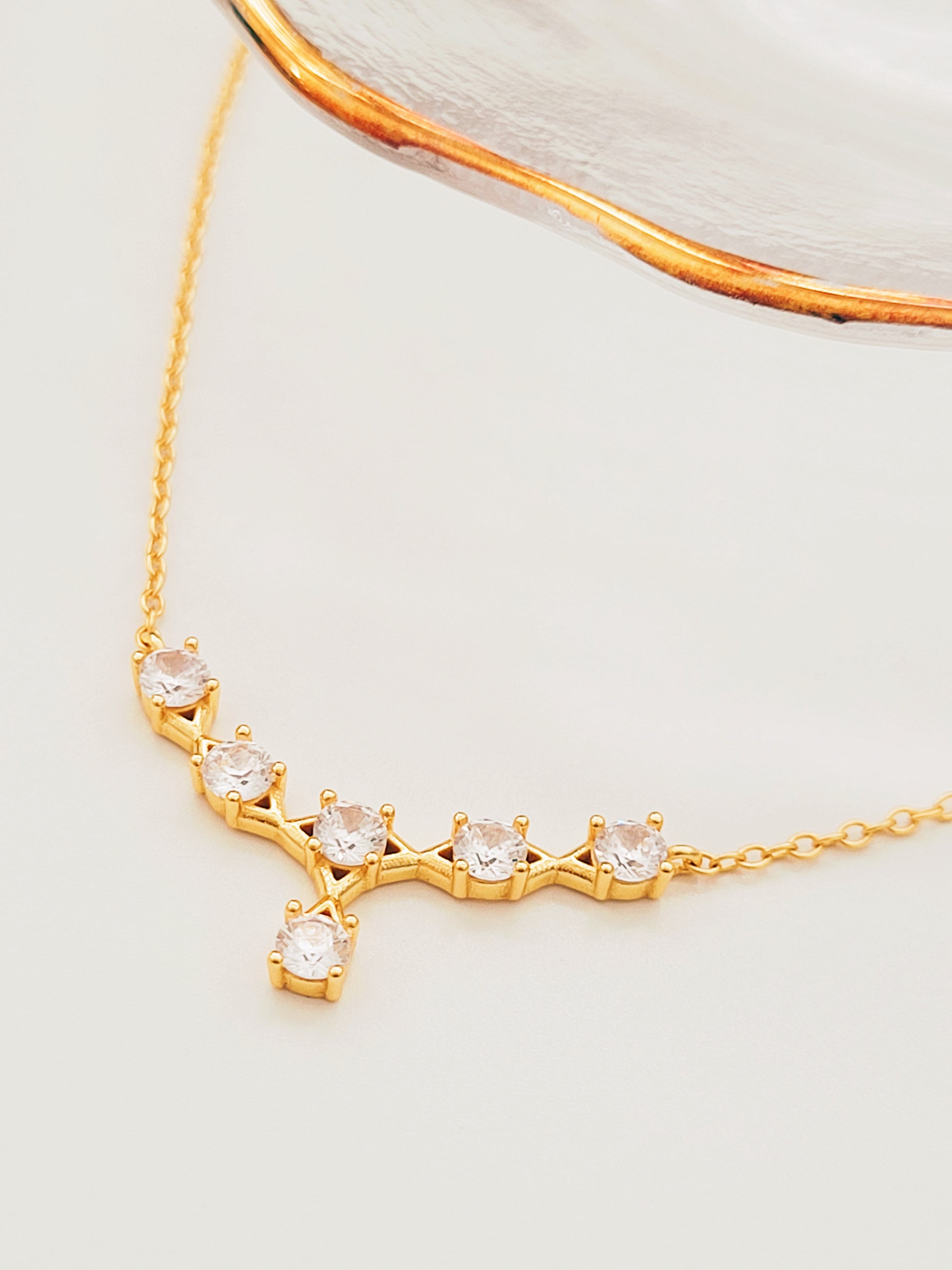 Close-up of a gold crown necklace with sparkling crystals, perfect for brides and special occasions.