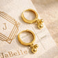 Gold hoop earrings with spherical charms on a JaBelle branded card, designed in UK.