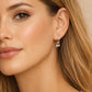 Close-up of a woman wearing a delicate hoop earring with dangle, unique and modern earring design.