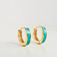 A stunning pair of gold and turquoise enamel huggie hoop earrings, perfect for adding a pop of color to any outfit.