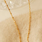 Close-up of a dainty gold necklace with square station beads, reflecting light with subtle shimmer, ideal for daily wear. Crafted in gold plated sterling silver, perfect jewellery for everyday wear. A thoughtful gift for birthdays, anniversaries or any occasions.