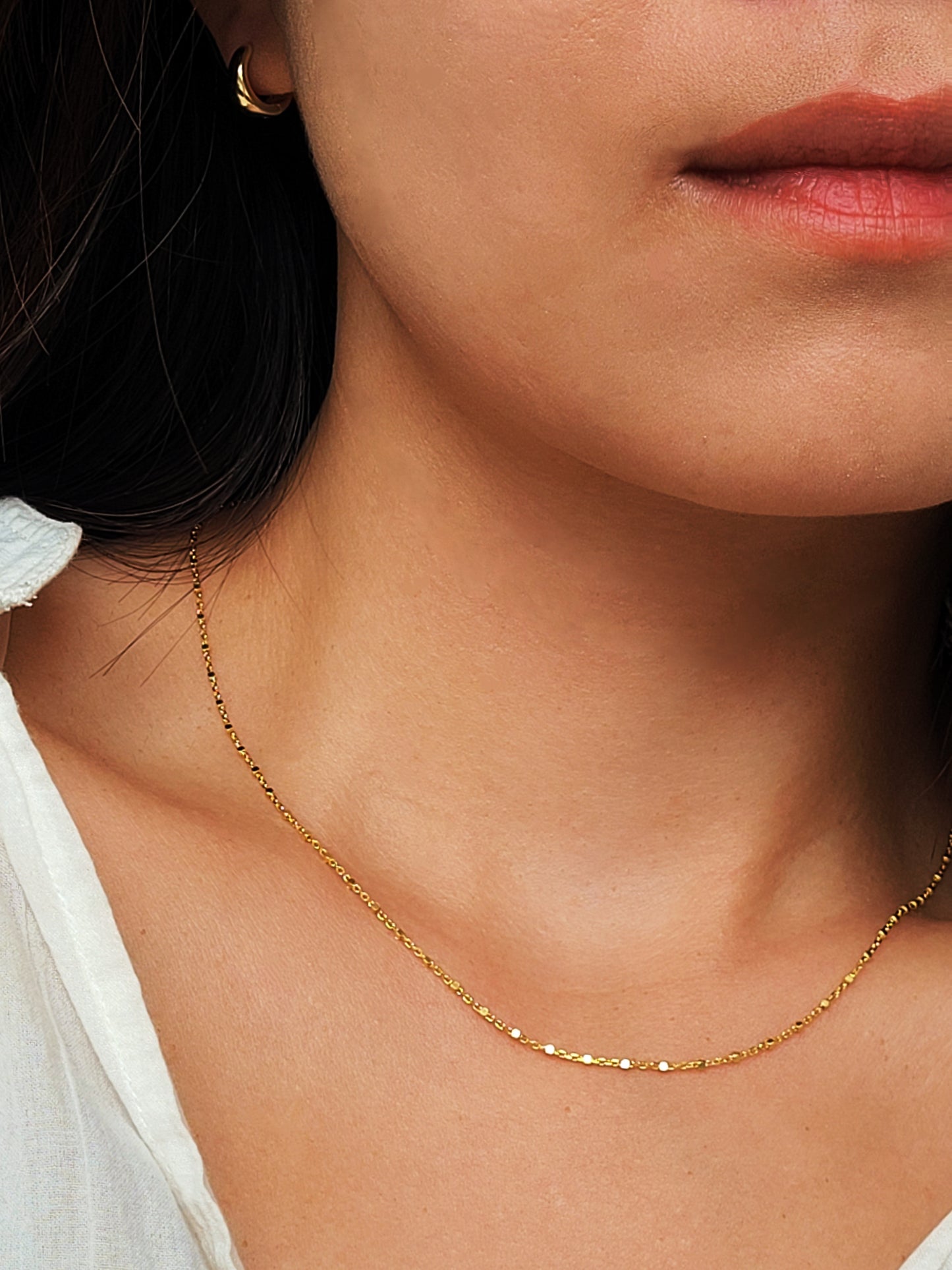 Close up of a women wearing minimalist gold chain necklace, delicate and dainty. Perfect gift for her