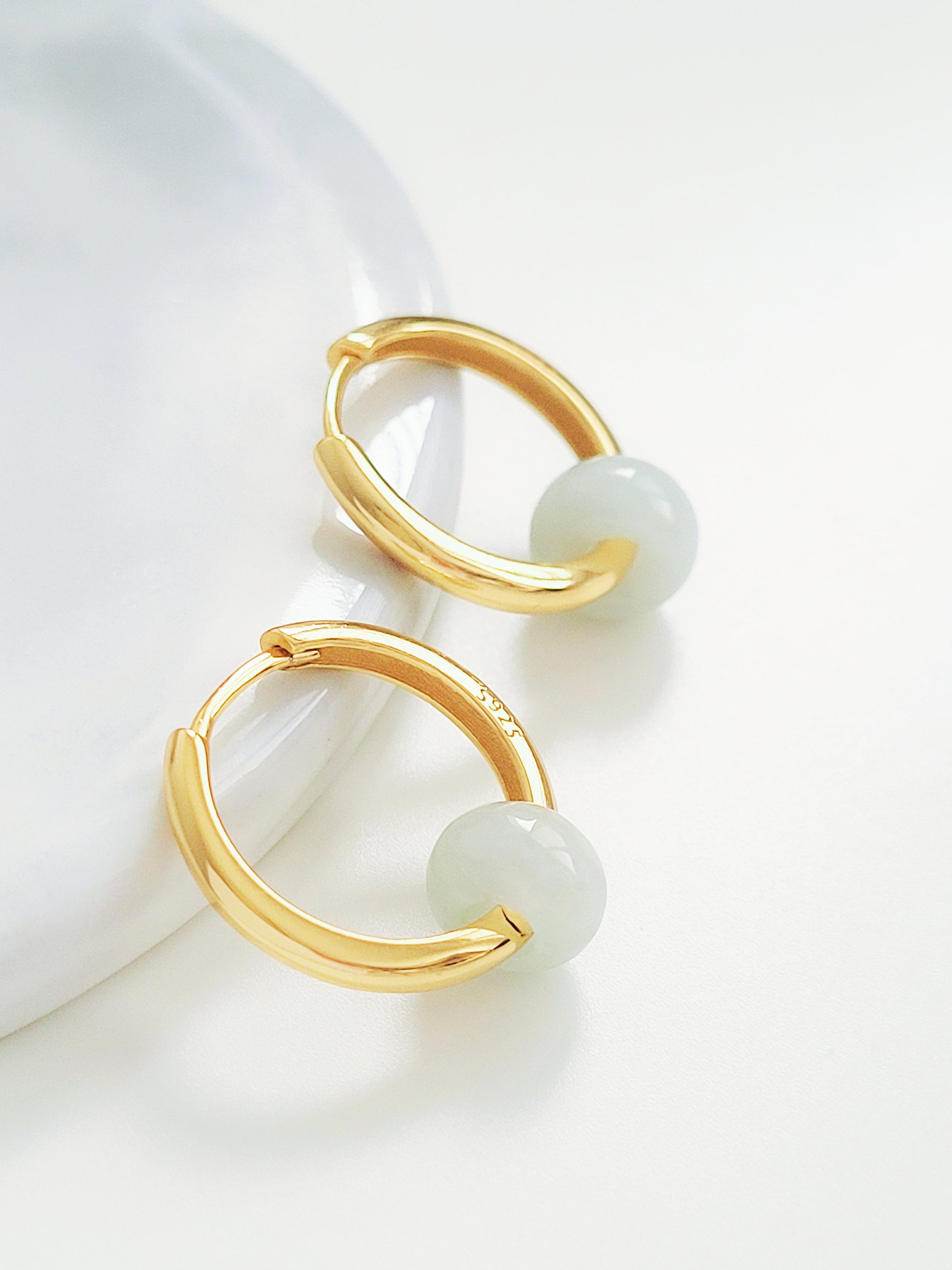 Luxurious gold hoop earrings  crafted in yellow gold vermeil embellished with pristine genuine jade stones, a statement of refined taste and elegance.