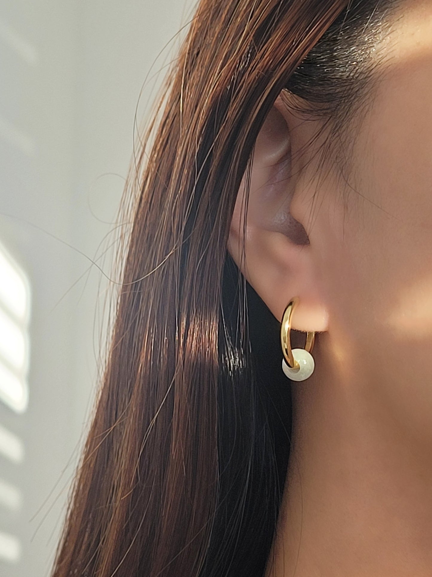 Elegant gold plated jade hoop earrings showcasing a rich green hue, perfect for adding a touch of sophistication to any outfit.