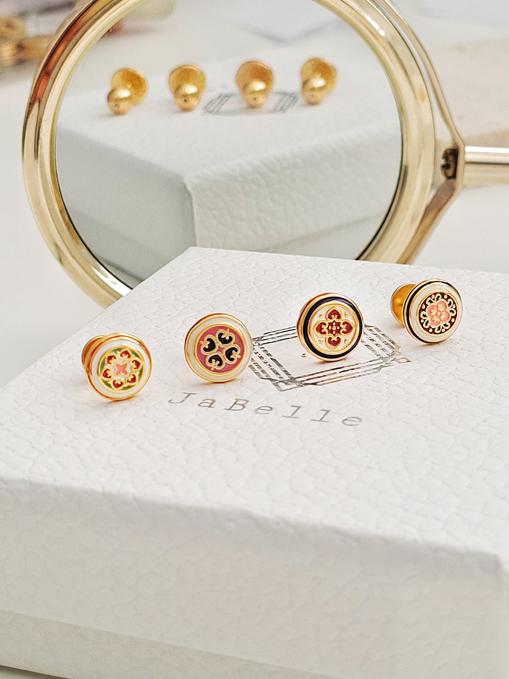 Four Retro Gothic tile pattern enamel stud earrings in red, blue, and gold are displaying on a jewelry box. The intricate design features a vintage-style pattern with a bold color combination, creating a striking and elegant look.