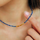 A woman wearing kyanite beaded gemstone choker necklace with gold vermeil accents, showing casing minimalist and elegant style. Perfect gift for her.