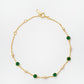 Gold station bracelet with green onyx gemstones and cubic zirconia stones on a white background