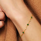 Gold bracelet with green onyx  gemstones on a wrist against a brown fabric background