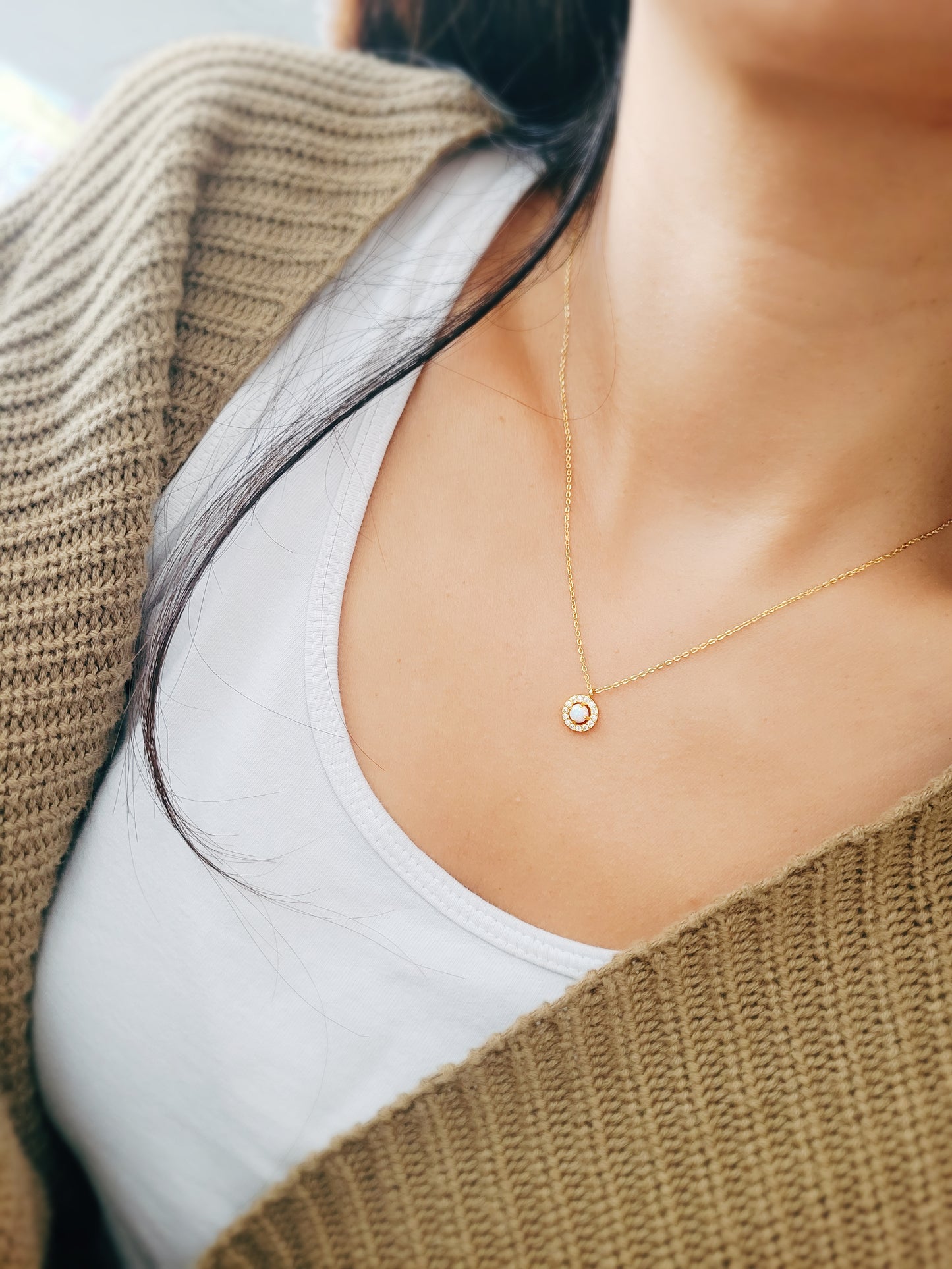 A woman wearing a high quality delicate opal necklace.