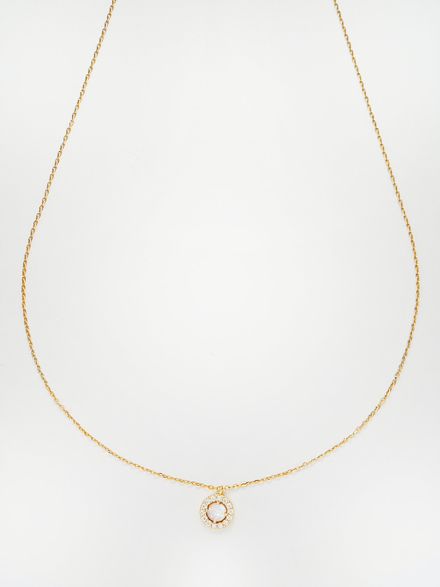 This opal necklace has a zirconia halo surround it. Crafted in 18ct gold plated on silver.