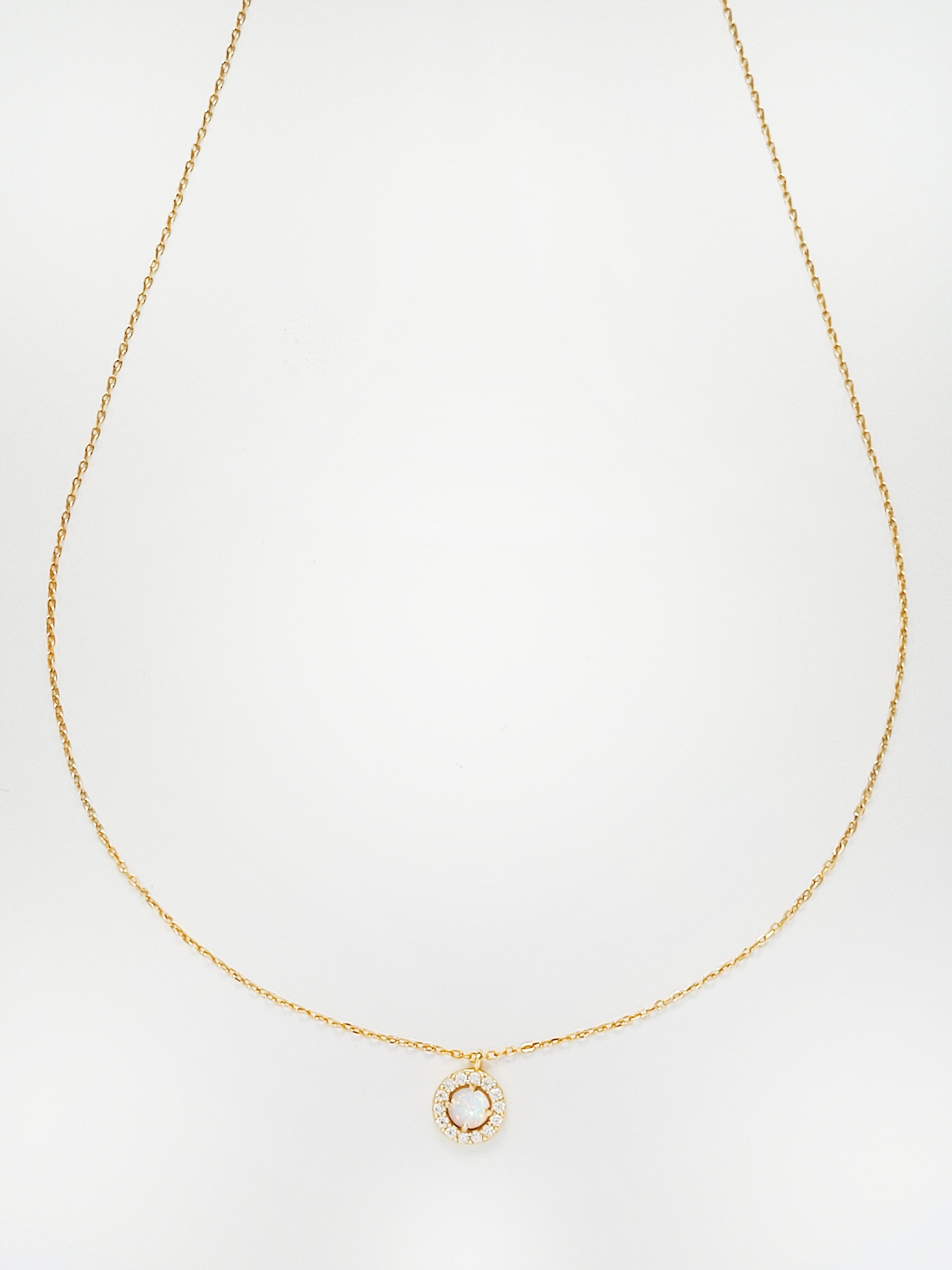 This opal necklace has a zirconia halo surround it. Crafted in 18ct gold plated on silver.