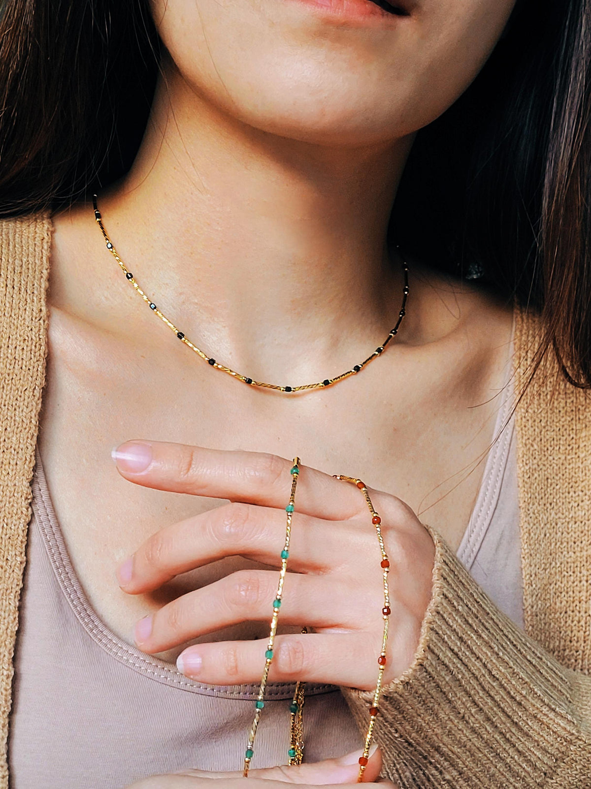 Close-up of a 22k gold vermeil choker necklace with black onyx beads worn around the neck. Crafted in 22k gold plated over sterling silver and natural gemstone. Perfect gift for mom.