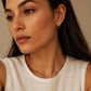 A woman in summer casual outfit wearing a yellow gold Medium Classic Hoop Earrings with pave cz diamond.