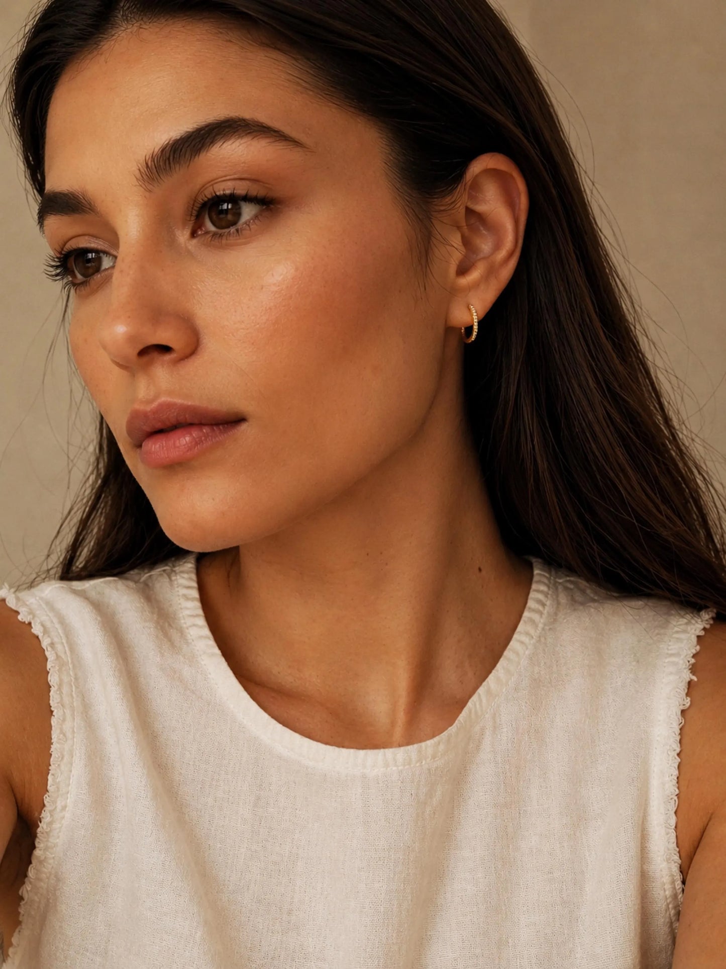 A woman in summer casual outfit wearing a yellow gold Medium Classic Hoop Earrings with pave cz diamond.
