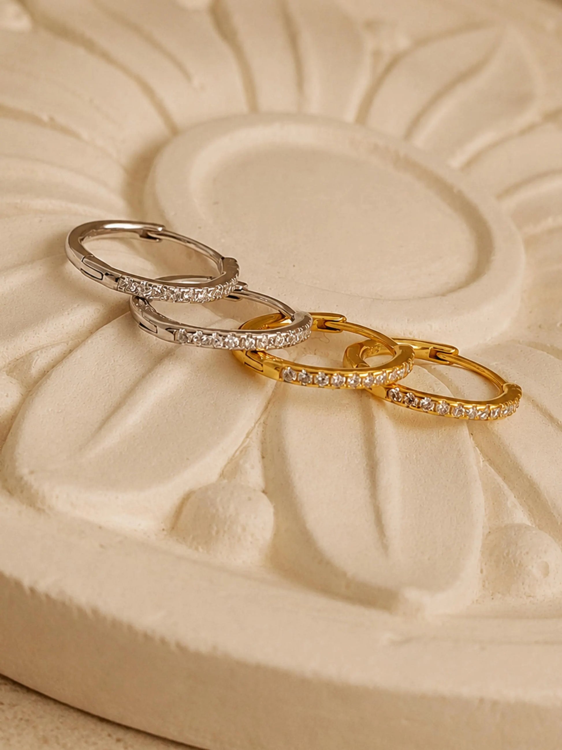 Dainty sterling silver and gold vermeil pavé diamond-like huggie hoop earrings, studded with small, clear cubic zirconia stones to add sparkle.