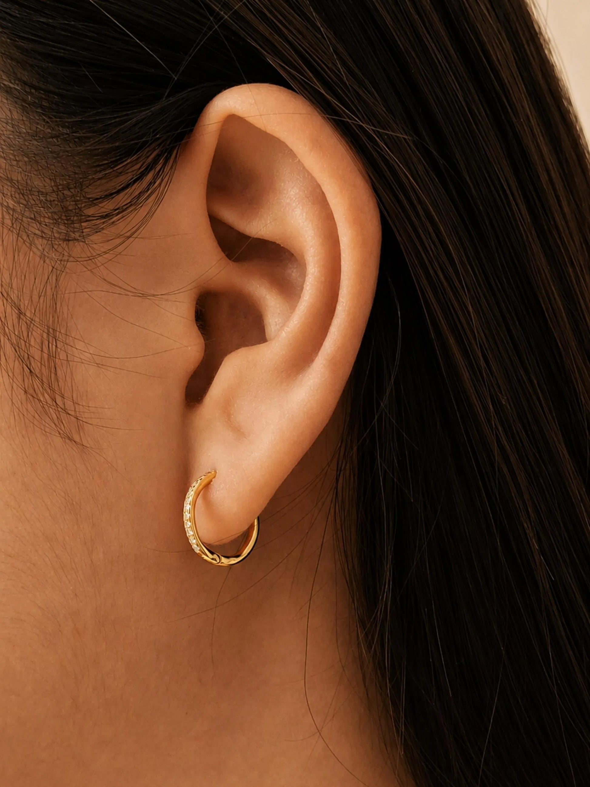 Dainty gold huggie hoop earrings featuring pavé-set lab grown diamond along the front, crafted in 18k gold vermeil. Minimalist earrings for everyday wear.