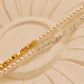 Two dainty 2mm glass pearl choker necklaces displayed on a decorative stone tile, one featuring textured 18k gold-plated nuggets and the other with sterling silver nuggets.