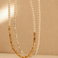 Two dainty 2mm glass pearl choker necklaces displayed on a decorative stone tile, one featuring textured 18k gold-plated nuggets and the other with sterling silver nuggets.