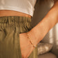 Woman wearing a two tone gold and silver beaded bracelet with a neutral background.