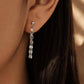 Close-up of a model wearing a delicate sterling silver tassel earring, showing how the shimmering flat-link fringe chains drape and catch the light for an elegant everyday look.