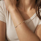 Close-up of a person wearing a delicate mixed metal bracelet with movable beads.