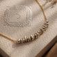 Organic sterling silver beads threaded onto a fine gold chain, displayed on JaBelle Jewellery box.