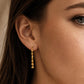 Model wearing a delicate gold vermeil tassel earring featuring multiple fine, shimmering flat-link chains that drape elegantly from a classic gold ball stud.