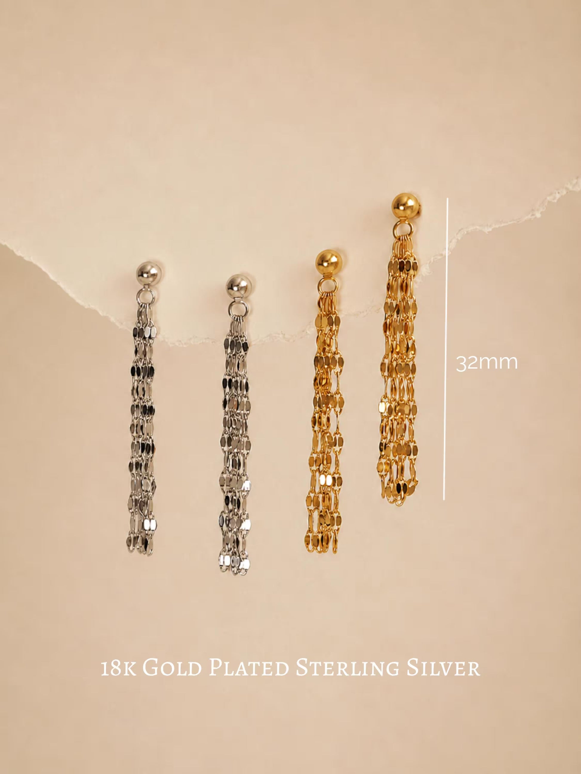 Two silver and two 18k gold-plated sterling silver tassel dangles hanging on a beige background with a 32mm measurement guide, showcasing the delicate flat-link fringe chain style.