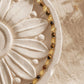 A delicate, dainty beaded necklace made of warm brown tiger's eye and light yellow citrine beads with gold accents displayed on a luxury flower plate.