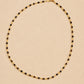 A luxury and dainty beaded necklace made of warm brown tiger's eye and light yellow citrine beads with gold accents displayed on a beige colored surface.